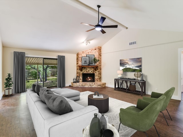 living room with ceiling fan, dark hardwood / wood-style floors, a brick fireplace, and vaulted ceiling with beams