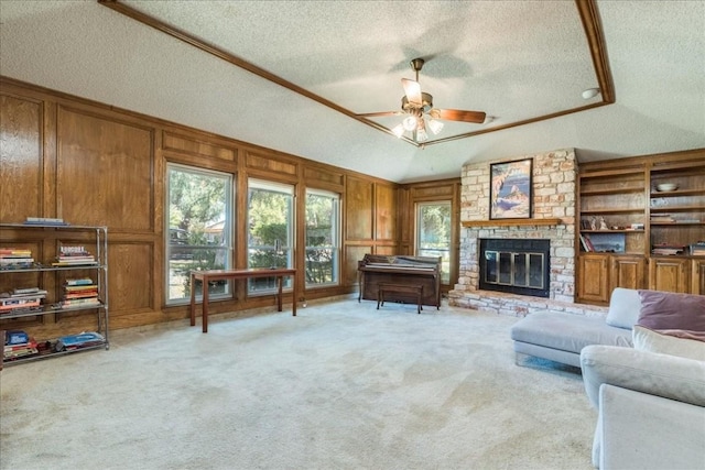 living room with light carpet, vaulted ceiling, ceiling fan, a textured ceiling, and a fireplace