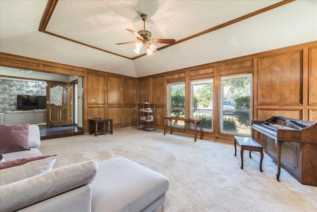 living room with lofted ceiling, light carpet, crown molding, ceiling fan, and a textured ceiling