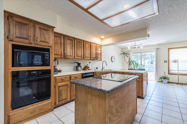 kitchen featuring a center island, black appliances, sink, light tile patterned flooring, and kitchen peninsula