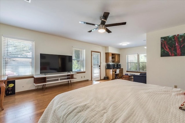 bedroom with multiple windows, ceiling fan, and hardwood / wood-style flooring