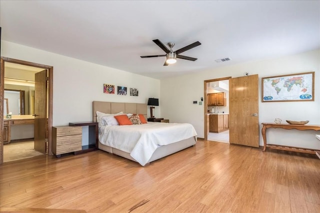 bedroom featuring light hardwood / wood-style flooring, ensuite bath, and ceiling fan