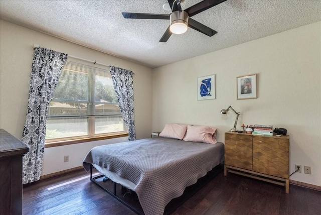 bedroom with a textured ceiling, ceiling fan, and dark wood-type flooring