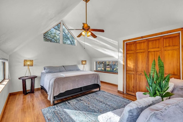 bedroom featuring ceiling fan, light hardwood / wood-style floors, and lofted ceiling