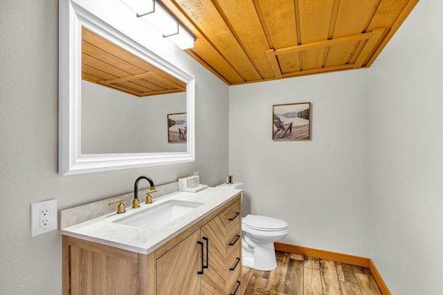 bathroom with hardwood / wood-style floors, vanity, toilet, and wooden ceiling