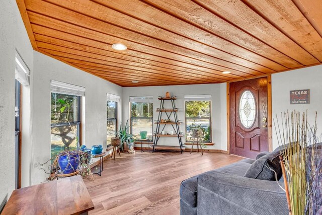 sunroom / solarium featuring a healthy amount of sunlight and wooden ceiling