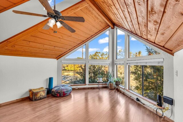 sunroom featuring lofted ceiling with beams, ceiling fan, and wooden ceiling