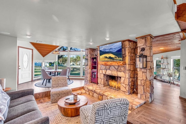 living room featuring light wood-type flooring and a stone fireplace