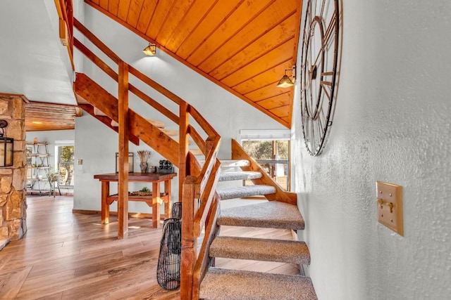 staircase with wood ceiling, vaulted ceiling, and wood-type flooring