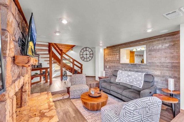 living room with light wood-type flooring and wooden walls