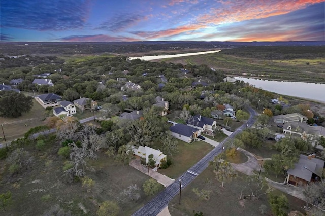 aerial view at dusk featuring a water view