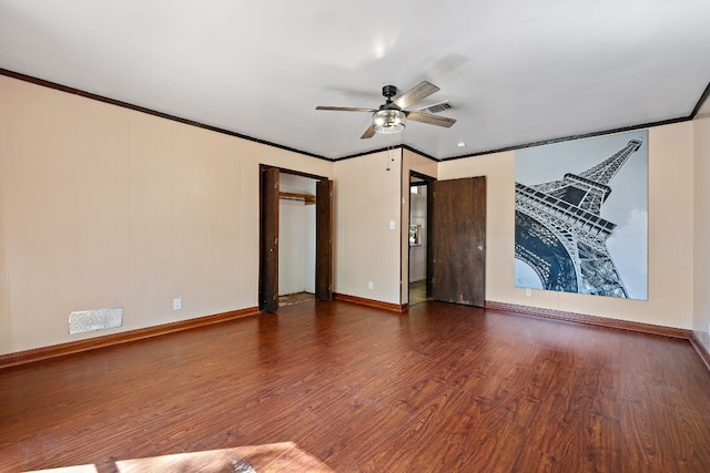 empty room with ceiling fan, ornamental molding, and dark wood-type flooring