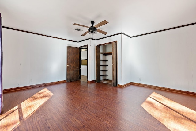 unfurnished bedroom with ceiling fan, crown molding, and dark wood-type flooring