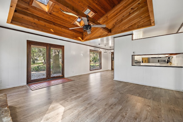 unfurnished living room featuring hardwood / wood-style floors, ceiling fan, plenty of natural light, and wood ceiling