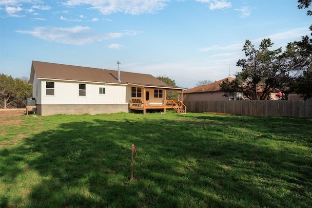 rear view of house with a lawn and a wooden deck