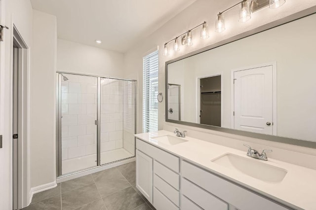 188 Weaver Ln, Bastrop, TX 78602 - full bathroom with a stall shower, double vanity, a spacious closet, and tile patterned flooring