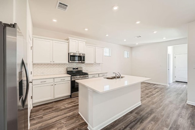 188 Weaver Ln, Bastrop, TX 78602 - kitchen featuring appliances with stainless steel finishes, dark wood-type flooring, decorative backsplash, white cabinetry, and recessed lighting