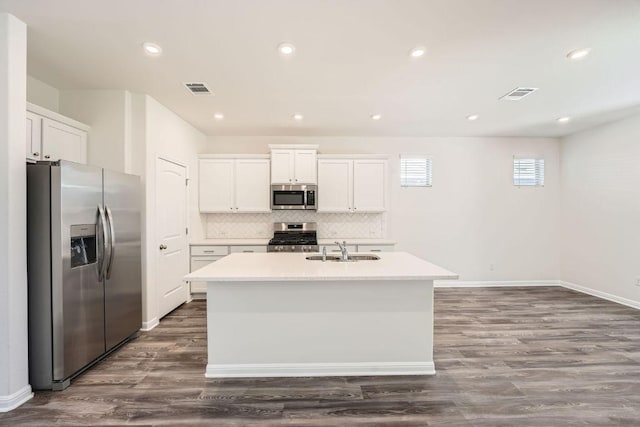 188 Weaver Ln, Bastrop, TX 78602 - kitchen with stainless steel appliances, an island with sink, white cabinetry, backsplash, and light countertops