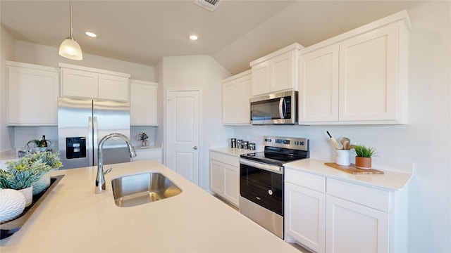 kitchen with white cabinets, decorative light fixtures, sink, and stainless steel appliances