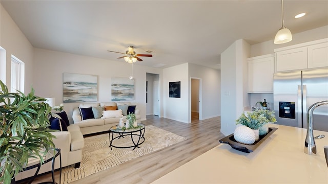 living room with ceiling fan and light wood-type flooring