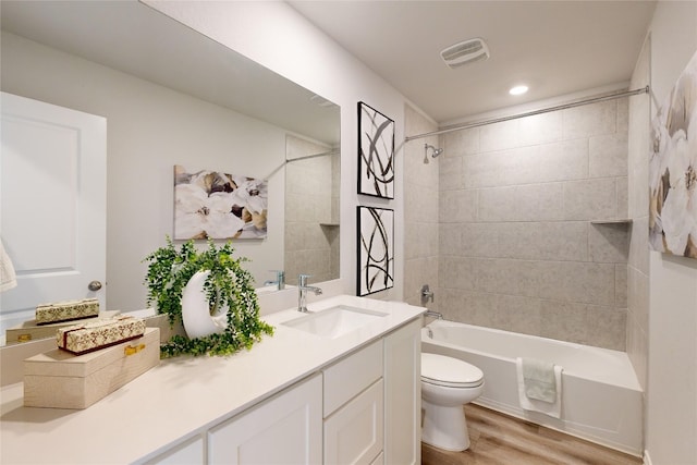 full bathroom featuring vanity, hardwood / wood-style flooring, toilet, and tiled shower / bath