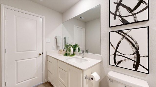 bathroom featuring vanity and toilet