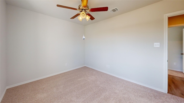 carpeted spare room featuring ceiling fan