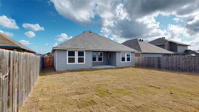 rear view of house featuring a lawn and a patio area