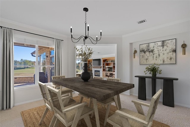 carpeted dining area featuring plenty of natural light, ornamental molding, and an inviting chandelier