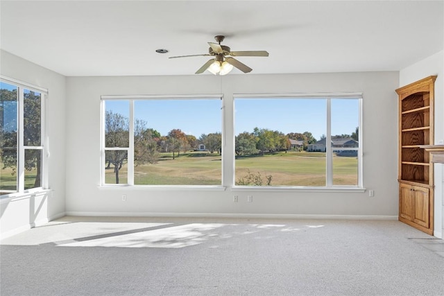 unfurnished sunroom featuring ceiling fan