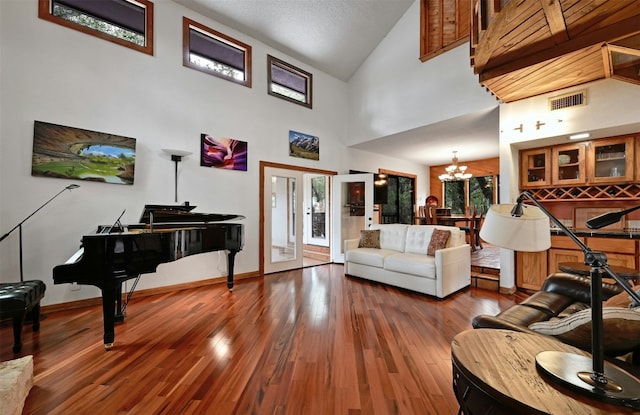 living room featuring french doors, high vaulted ceiling, a chandelier, and wood-type flooring