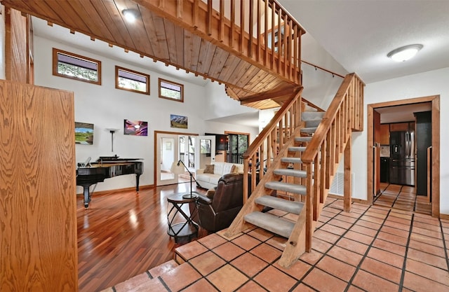 staircase with a high ceiling, hardwood / wood-style flooring, and french doors