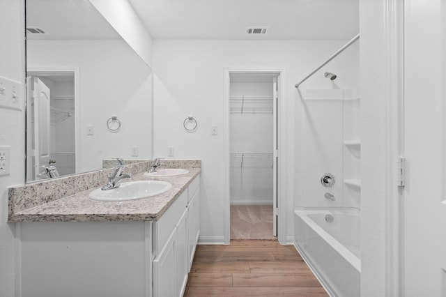 bathroom with bathing tub / shower combination, hardwood / wood-style floors, and vanity