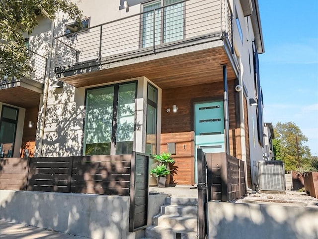 property entrance with a balcony and central AC unit