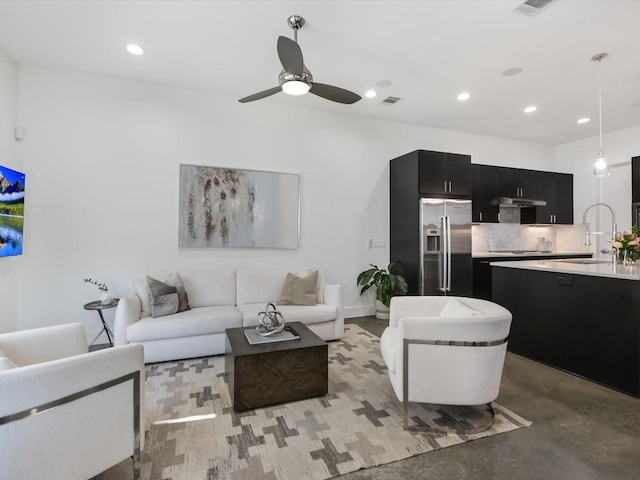 living room with ceiling fan and sink