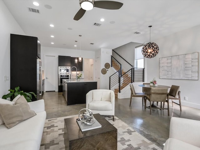 living room featuring ceiling fan and sink