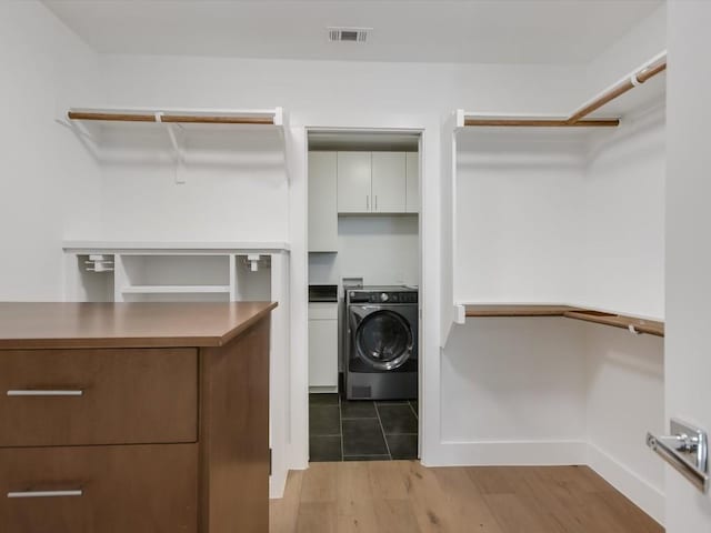 walk in closet featuring washer / dryer and light hardwood / wood-style flooring