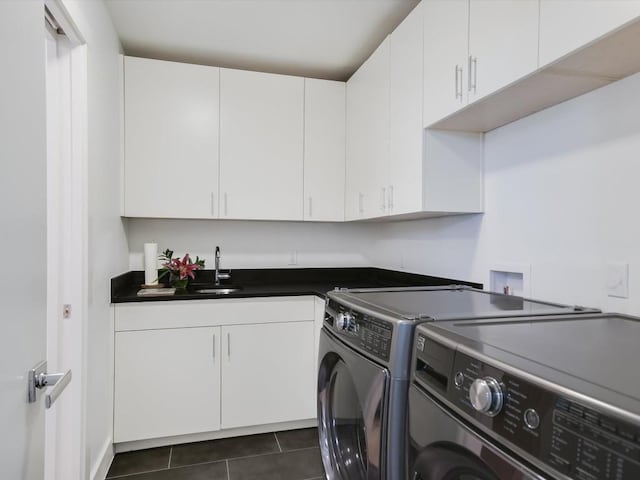 washroom featuring cabinets, washing machine and dryer, dark tile patterned floors, and sink