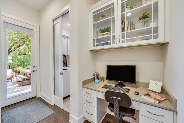 home office featuring dark hardwood / wood-style flooring and built in desk