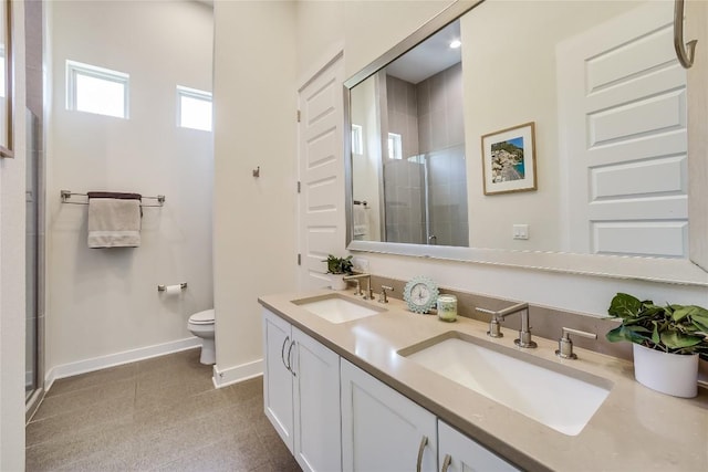 bathroom with vanity, toilet, and a shower with door