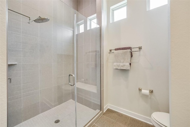 bathroom with tile patterned flooring, toilet, and a shower with door