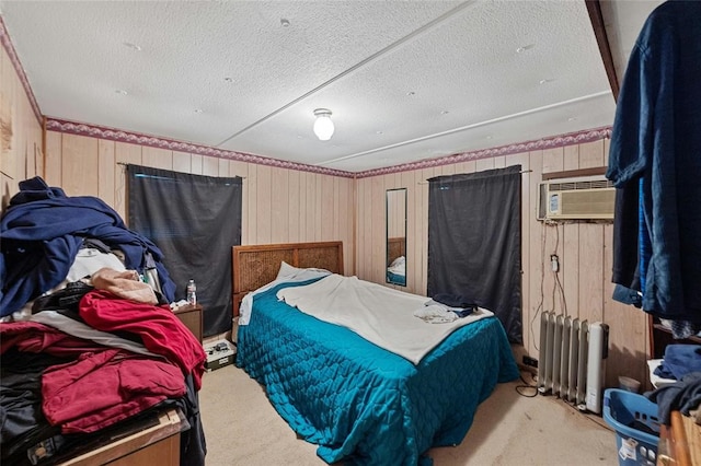 carpeted bedroom with radiator heating unit, a textured ceiling, a wall mounted AC, and wood walls