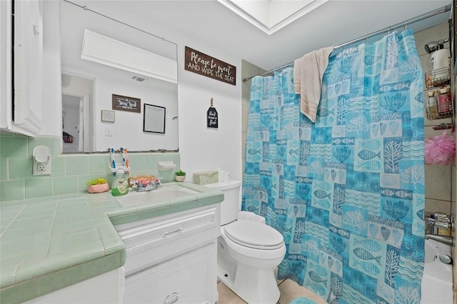 bathroom with backsplash, a shower with curtain, vanity, and toilet