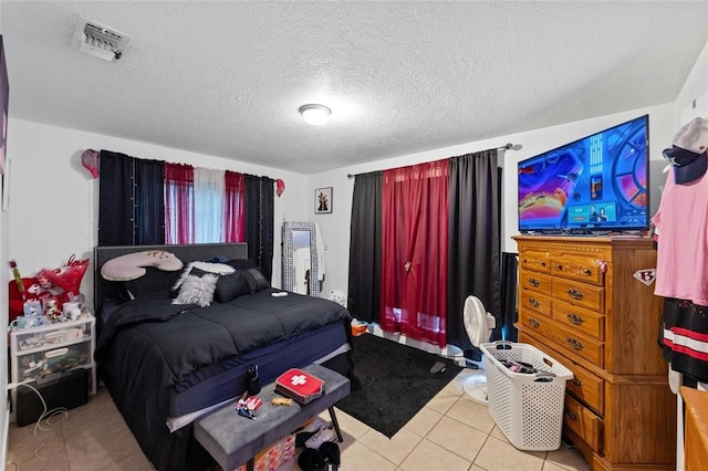 bedroom with light tile patterned floors and a textured ceiling