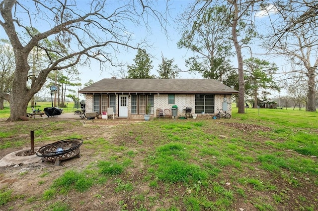 view of front facade with a front yard and an outdoor fire pit