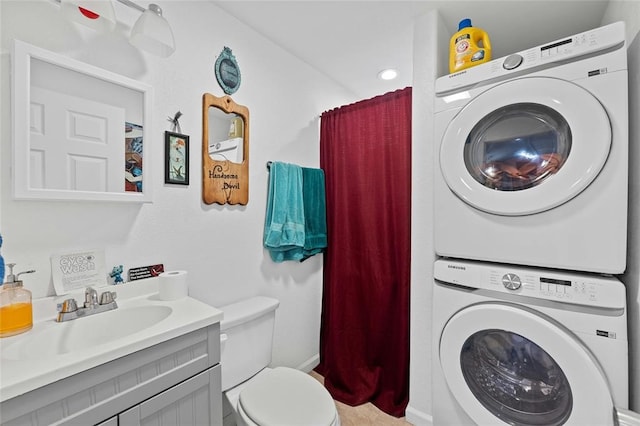 bathroom featuring stacked washer and dryer, vanity, and toilet