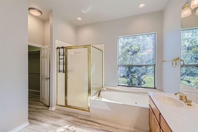 bathroom featuring hardwood / wood-style flooring, vanity, and separate shower and tub