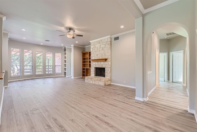 unfurnished living room featuring a stone fireplace, ceiling fan, light hardwood / wood-style flooring, and ornamental molding