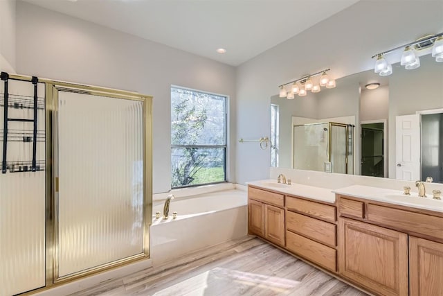 bathroom featuring hardwood / wood-style flooring, vanity, and separate shower and tub