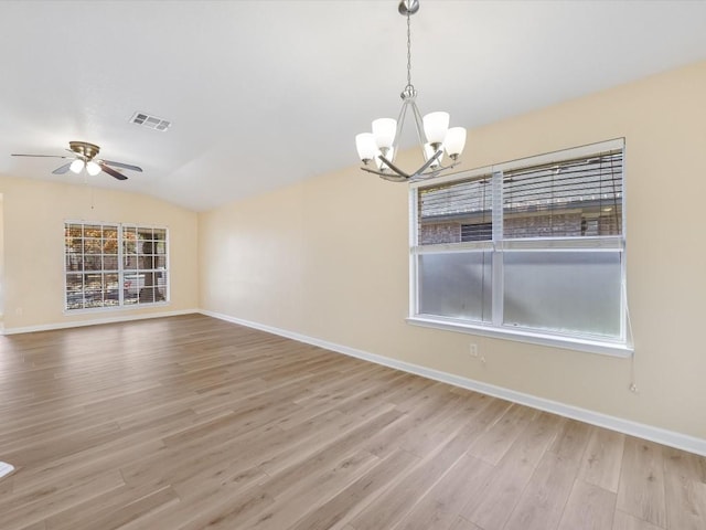 spare room featuring light hardwood / wood-style floors, vaulted ceiling, and plenty of natural light